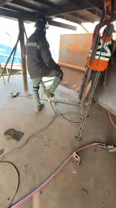 Soldador trabajando sobre la estructura de una embarcación en construcción en caleta Infiernillo, Talcahuano